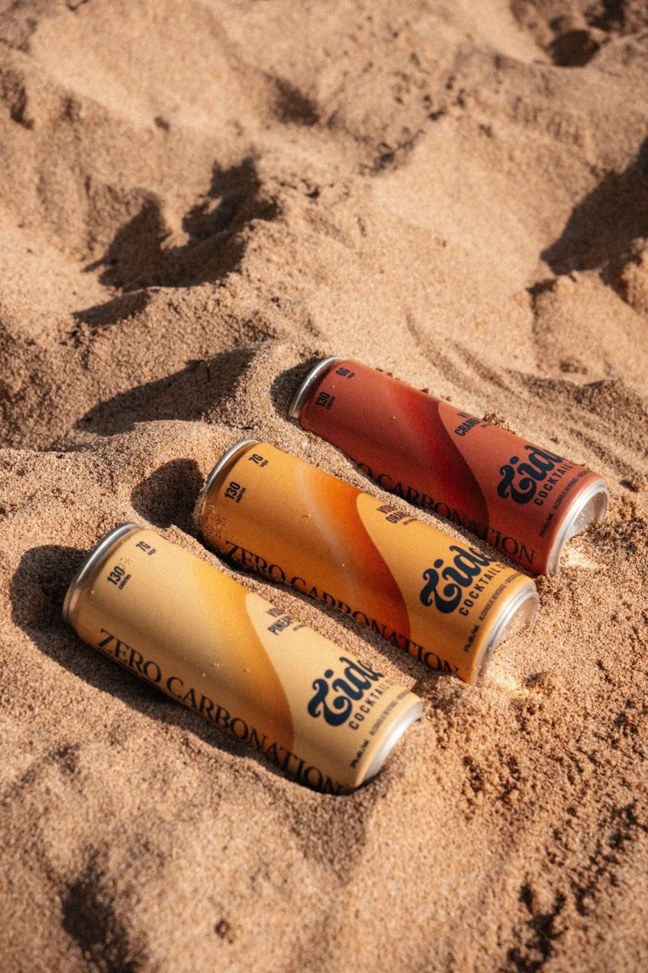 Tide Cocktails cans in the sand